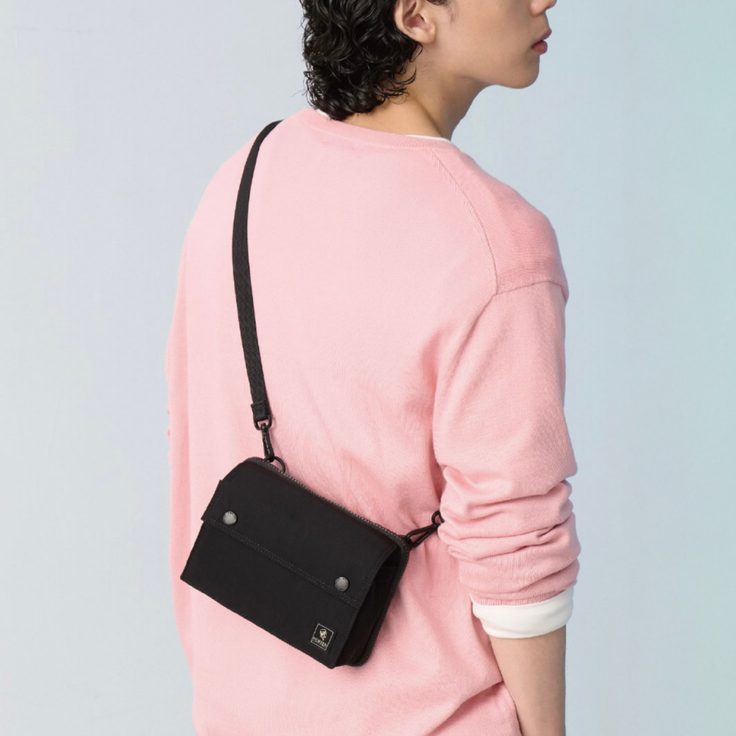 Model wearing the PORTER INTERNATIONAL Mid Shoulder Bag (M) 'Black', showcasing a lightweight everyday crossbody bag with a minimalist design.