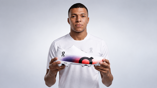 Kylian Mbappé holding the On Cloudboom Strike LS running shoe