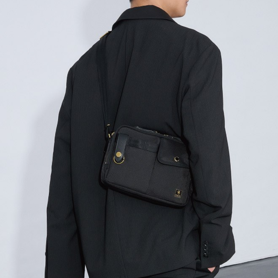 Model wearing the PORTER INTERNATIONAL New Heat Shoulder Bag (S) 'Black', showcasing a compact everyday shoulder bag with a lightweight design and adjustable strap.